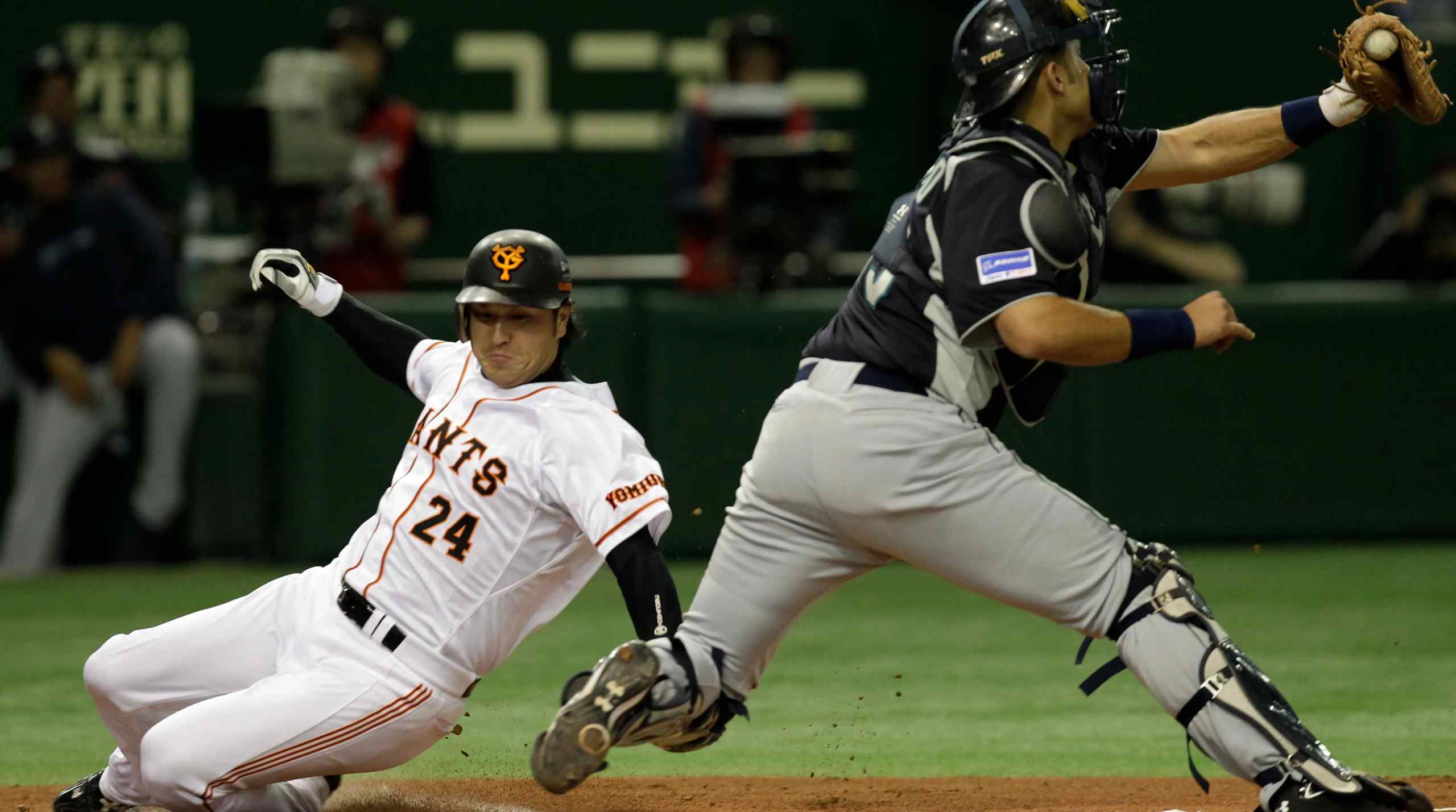 A Yomiuri Giants player slides into home base in a Nippon Professional Baseball game.